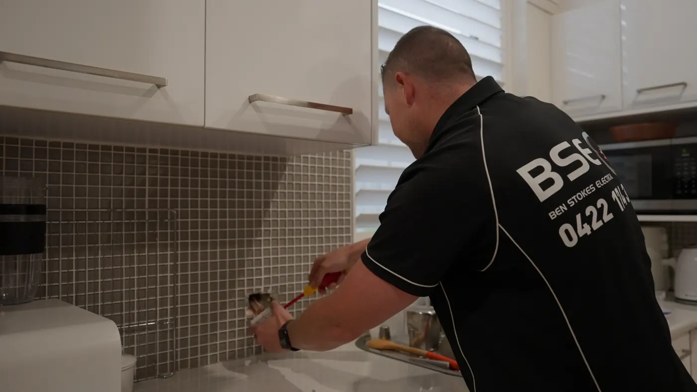 Ben fitting a power point in a kitchen
