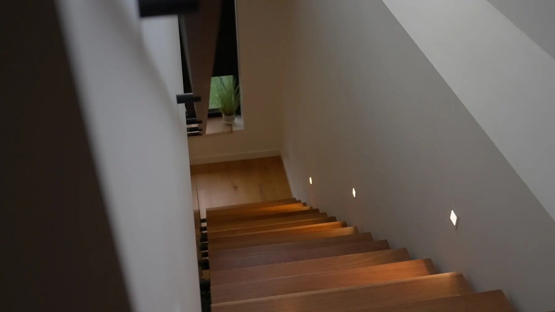Step lights glowing on a timber staircase